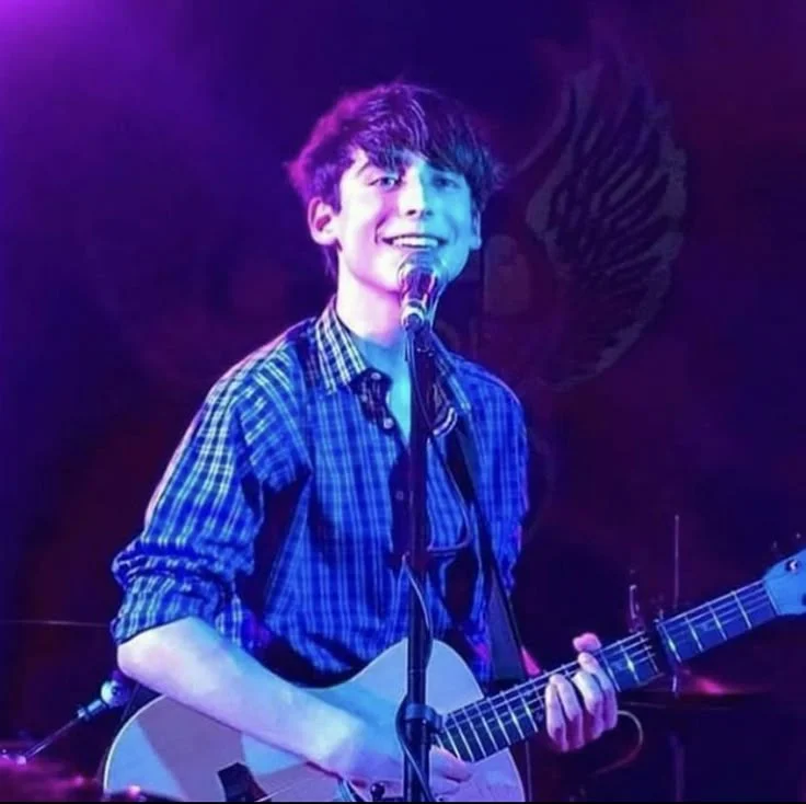 Aidan Gallagher cantando guitarra escenario Aidan Gallagher cantando guitarra escenario